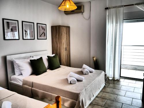 a bedroom with a bed with towels on it at Seaside Stay Makrygialos in Makrygialos