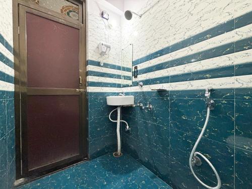 a blue tiled bathroom with a shower and a door at Hotel Radha Rani palace in Ayodhya