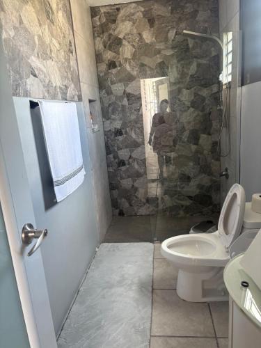 a bathroom with a shower with a toilet and a sink at serenity in Fajardo