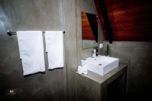 a bathroom with a white sink and towels at HAVENRO Weligama in Weligama