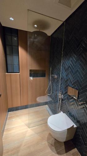ein Badezimmer mit Toilette und Glasdusche in der Unterkunft Nahi Suite in Yanbu