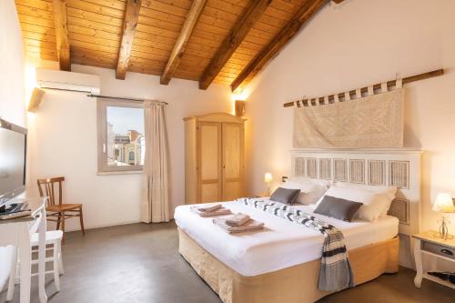a bedroom with a large white bed and a desk at B&B Stentadì in Quartucciu