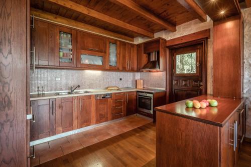 a kitchen with wooden cabinets and apples on the counter at Melissa Stone House in Alykes