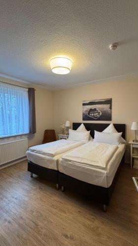 a bedroom with a large bed with white sheets and pillows at Zur Schlossbrücke in Ritterhude