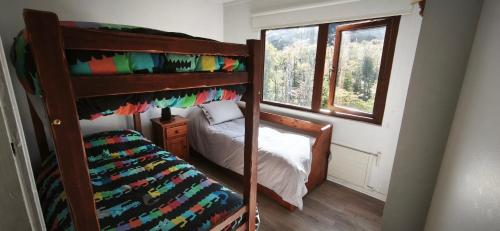 a bedroom with two bunk beds and a window at Apartamento Termas de Chillán in Nevados de Chillan