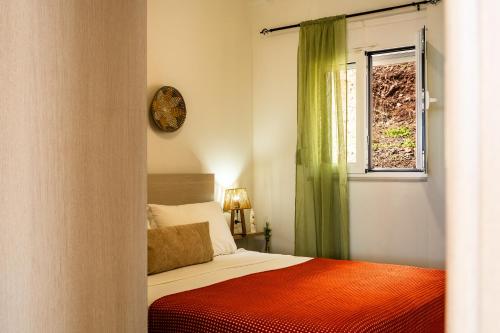 a bedroom with a bed and a window and a clock at Vrachos Nature Lodges DAPHNE 2, Private pool in Agia Galini