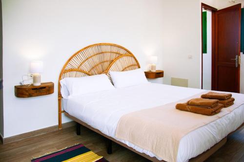 a bedroom with a large white bed with brown towels on it at Muellito de Famara in Famara