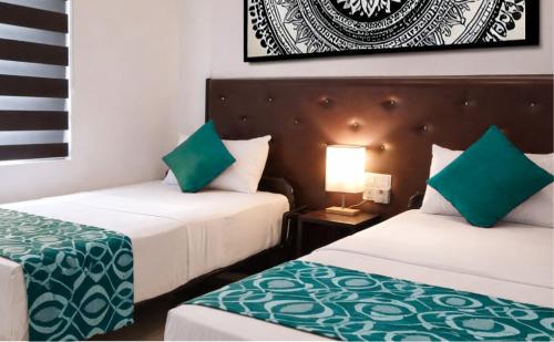 a hotel room with two beds with green sheets at TBRS By Platinum Hotels in Trincomalee