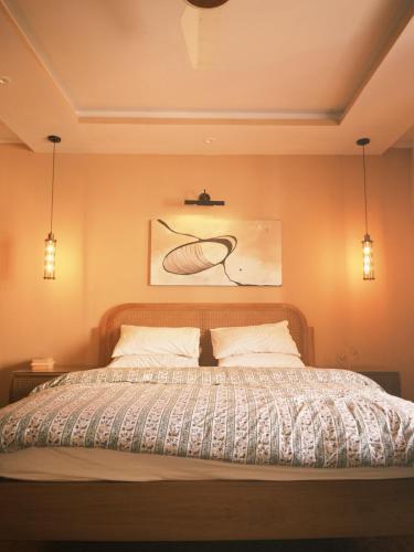 a bedroom with a bed with two lights on it at Maison Veyra in Rawalpindi