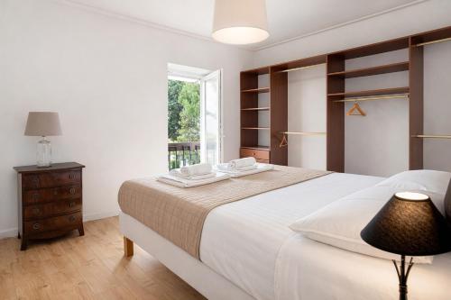 a white bedroom with a large bed and a window at PAREDE APARTMENT 2 in Cascais