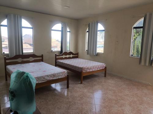 two beds in a room with windows and windowsktop at Paraíso do Abais, house for rent in Estância