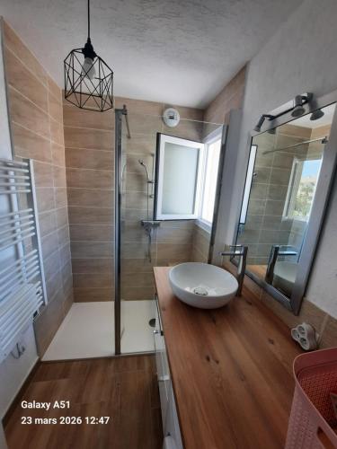 a bathroom with a sink and a glass shower at Coeur Marina climatisé terrasse parking in Fréjus