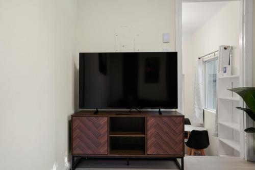 a flat screen tv sitting on top of a wooden entertainment center at Cozy Affordable Private Rooms Newly Renovated near SF Transportation in San Francisco
