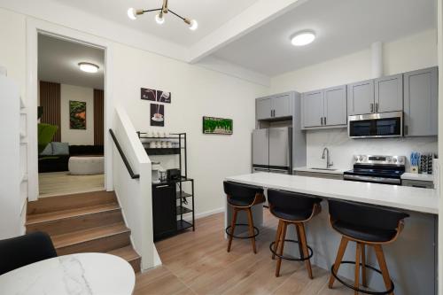 a kitchen with white cabinets and black bar stools at Cozy Affordable Private Rooms Newly Renovated near SF Transportation in San Francisco