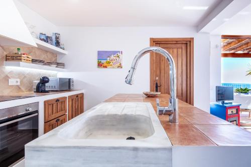 a kitchen with a sink in the middle of a counter at Rincón de Hada in Mojácar