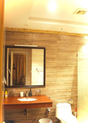 a bathroom with a sink and a mirror and a toilet at Maison Veyra in Rawalpindi