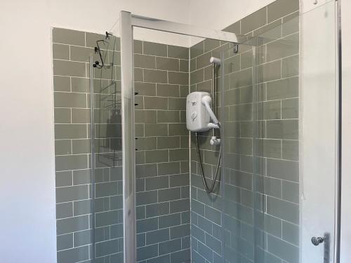 a shower in a bathroom with green tiles at Rose Cozy House in Stockton-on-Tees
