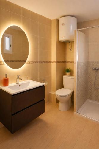a bathroom with a sink and a toilet and a mirror at Hotel Ancla in Oropesa del Mar