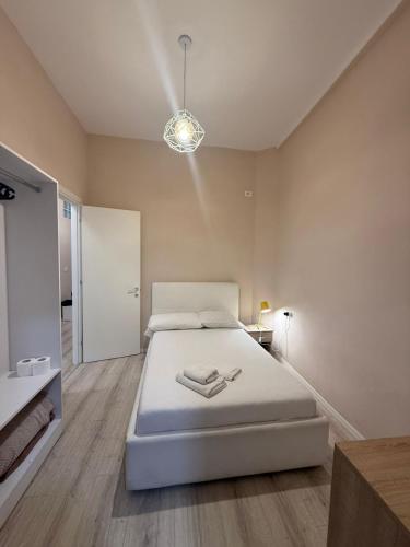 a bedroom with a white bed and a light fixture at Limore Hostel in Tirana