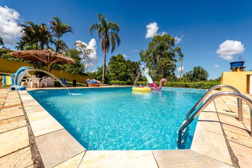 a swimming pool with a water slide in a resort at Paraíso com Piscina, Churrasqueira, Wi-Fi e Karaokê in Ibiúna