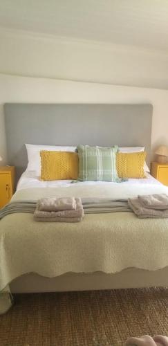 a bed with two pillows and two towels on it at Die Kuierhuis in Ventersburg