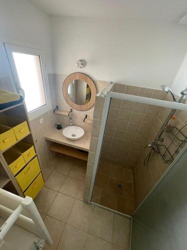 a bathroom with a sink and a mirror at Mini villa proche plage Santa Giulia in Porto-Vecchio