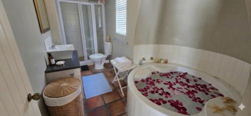 a bathroom with a tub filled with red roses at Verdoesie Jacobsbaai in Jacobs Bay