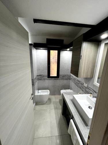 a bathroom with a sink and a toilet and a mirror at Casa Cristina in Costa Rei
