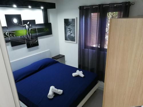 a bedroom with a blue bed and two white towels at Casa Cristina in Costa Rei