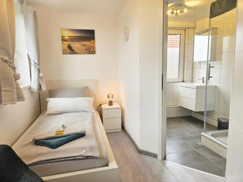 a small bedroom with a bed and a bathroom at Pension Hohaus in Neuharlingersiel