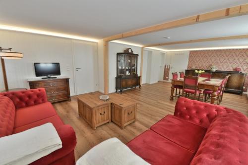 a living room with a red couch and a table at Ferienwohnung Harmony "Residenz" in Leisnig