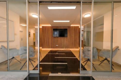 a conference room with glass walls and a tv at Old Town Guest Accommodation in Kranj