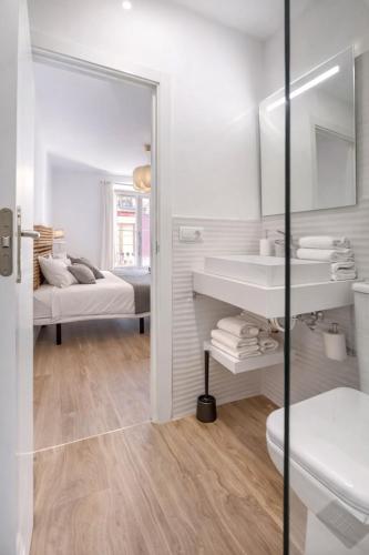 a white bathroom with a sink and a mirror at 22CaLQuEROL Boutique centro suite lux in Puigcerdà
