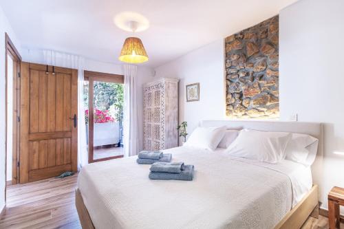 a bedroom with a large white bed with towels on it at Rincón de Hada in Mojácar