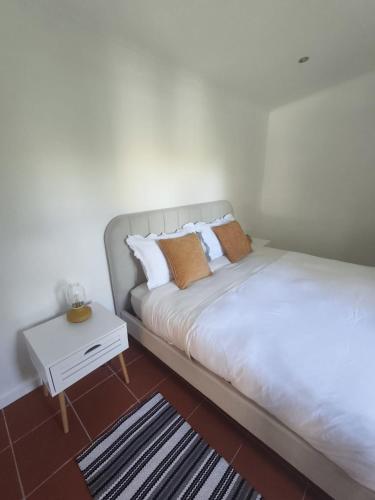 a bedroom with two beds and a side table at Oficina do Avô in Villa Nogueira
