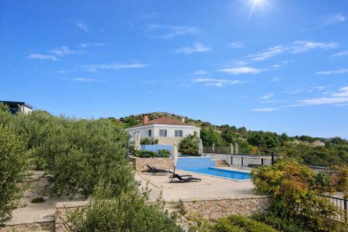 a villa with a swimming pool and a house at Panorama Mobilehome Vista Kornati with Pool in Drage