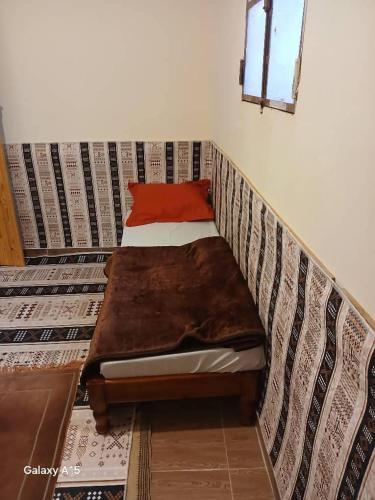 a bed in a bed frame in a room at Maison authentique in Bou Noura