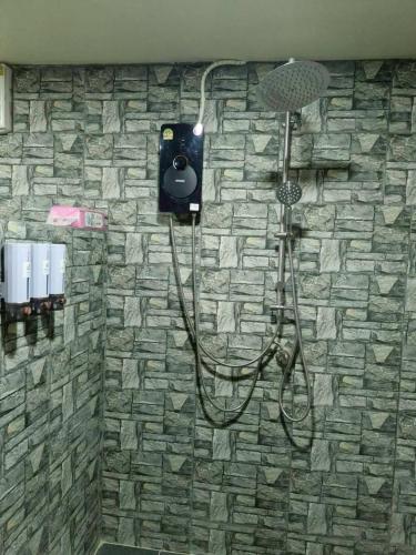 a bathroom with a shower with a stone wall at Echo Falls Khanom in Ban Nua Tha