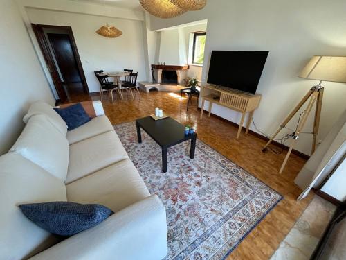 a living room with a white couch and a television at The Urban Terrace in Figueira da Foz