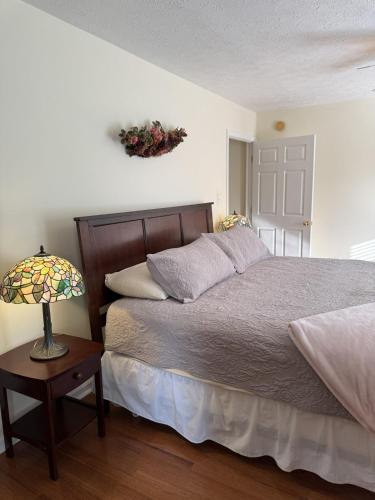 a bedroom with a bed and a lamp on a table at Three Springs Plus in Lovingston