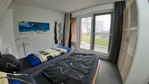 a bedroom with a bed and a large window at Ostseeferienwohnung - Bossert in Kronsgaard