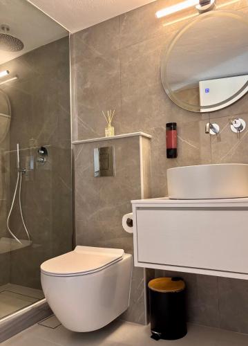 a bathroom with a toilet and a sink and a mirror at BellaDiAnna Apartment in Symi