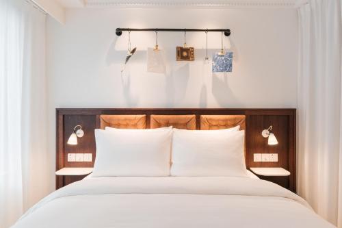 a bedroom with a large bed with white pillows at Ruby Stella Hotel London by IHG in London
