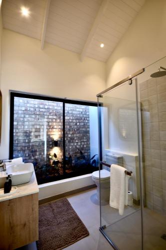 a bathroom with a shower and a sink and a toilet at Rustic Hills 39 in Swakopmund