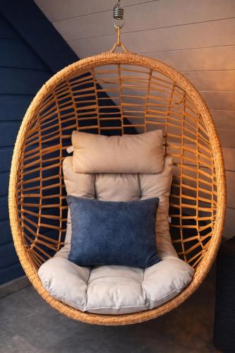 a hanging rattan chair with a pillow at Suite la Parenthèse cosy avec salon prive 25m2 Wifi Netflix Duclair in Duclair
