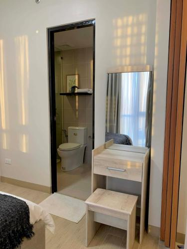 a bathroom with a toilet and a mirror at The SB Residences Luxury Executive Studio in Iloilo City