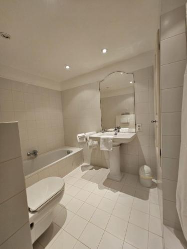 a bathroom with a toilet and a sink and a tub at La Ribaude in Crestet
