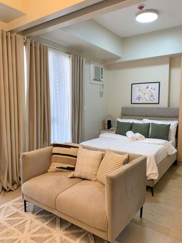 a bedroom with a large bed and a couch at The SB Residences Luxury Executive Studio in Iloilo City
