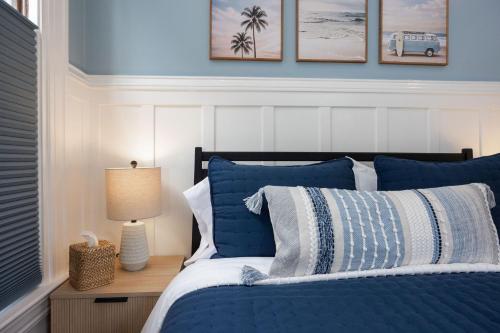 a bedroom with a bed with blue and white pillows at BytheSea Inn in Half Moon Bay