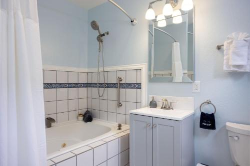 a bathroom with a tub and a sink and a toilet at BytheSea Inn in Half Moon Bay